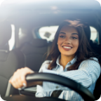 A woman with relaxed posture drives a vehicle.